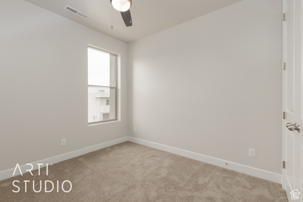 Carpeted spare room with ceiling fan