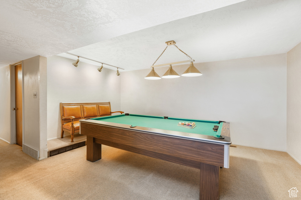 Game room with a textured ceiling, carpet flooring, rail lighting, and pool table