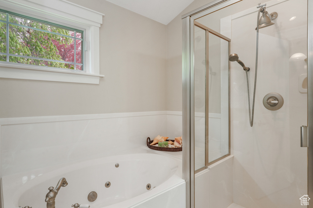 Bathroom featuring vaulted ceiling and plus walk in shower