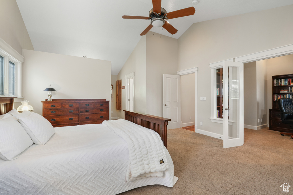 Carpeted bedroom featuring high vaulted ceiling, ceiling fan, and french doors