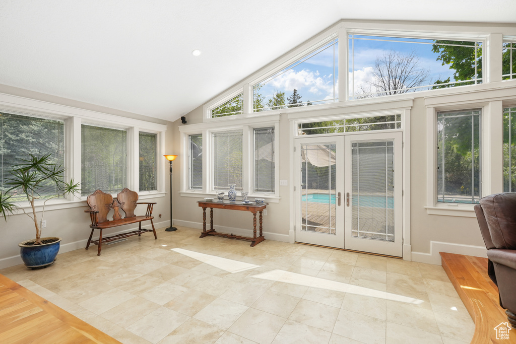 Sunroom / solarium with french doors, plenty of natural light, and vaulted ceiling