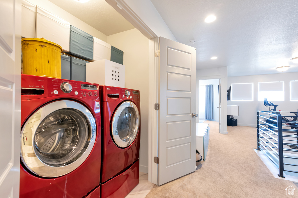 Laundry room with carpet flooring and washing machine and clothes dryer