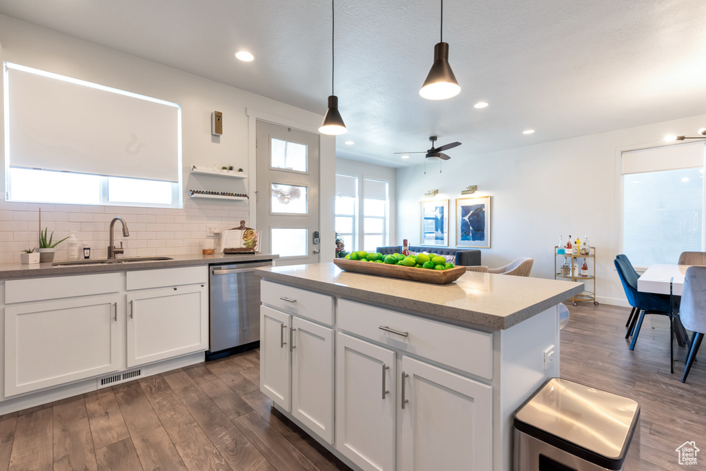 Kitchen featuring sink, dishwasher, tasteful backsplash, dark hardwood / wood-style floors, and pendant lighting
