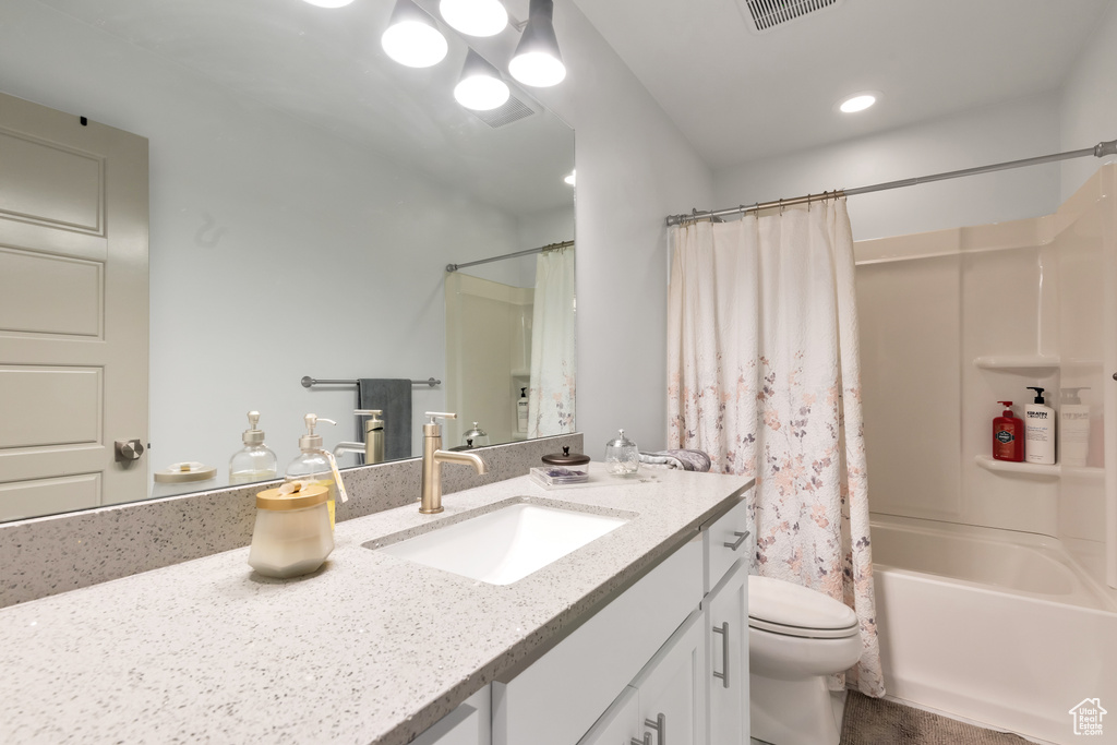 Full bathroom with shower / bath combination with curtain, toilet, and vanity with extensive cabinet space