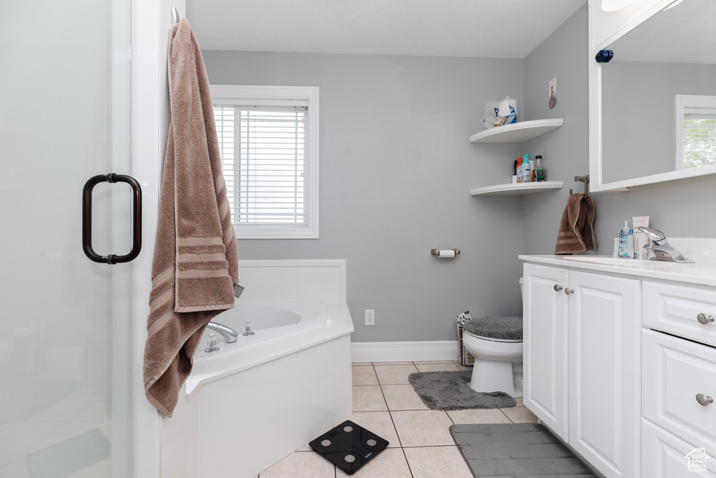 Bathroom with toilet, a bathing tub, vanity, and tile flooring