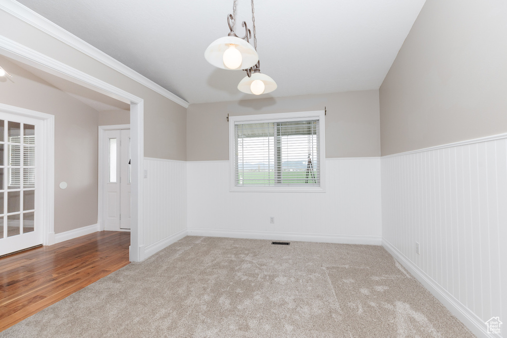 Spare room featuring crown molding and carpet flooring