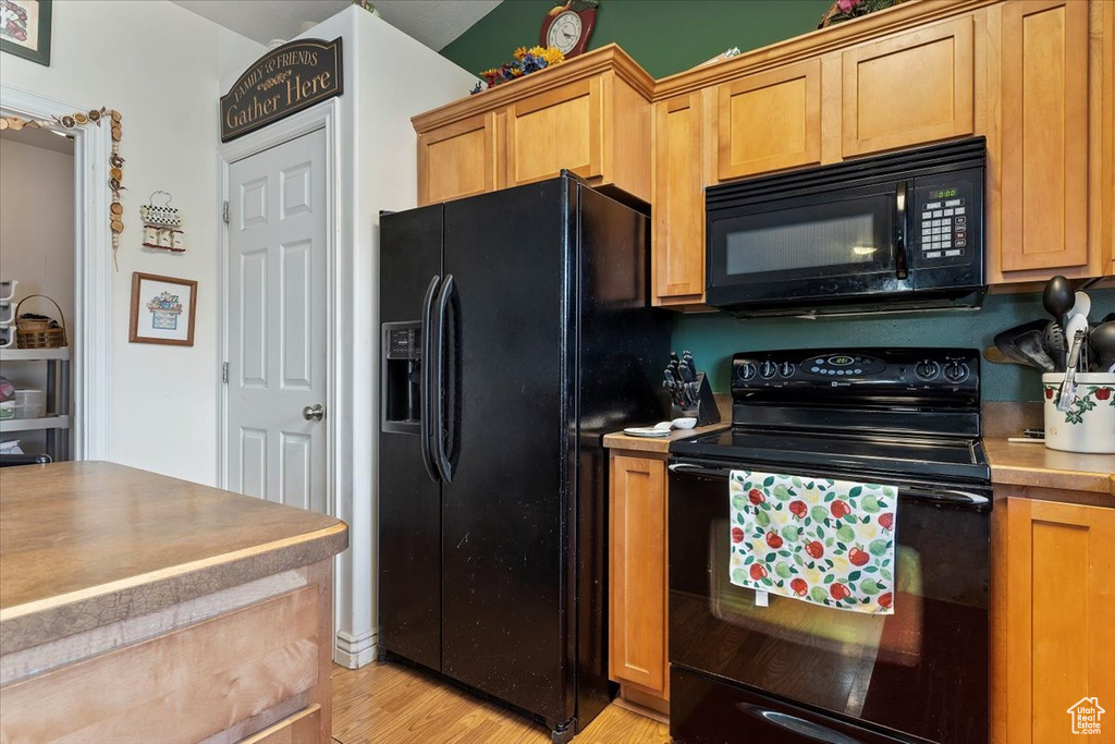 Kitchen featuring light wood-type flooring and black appliances