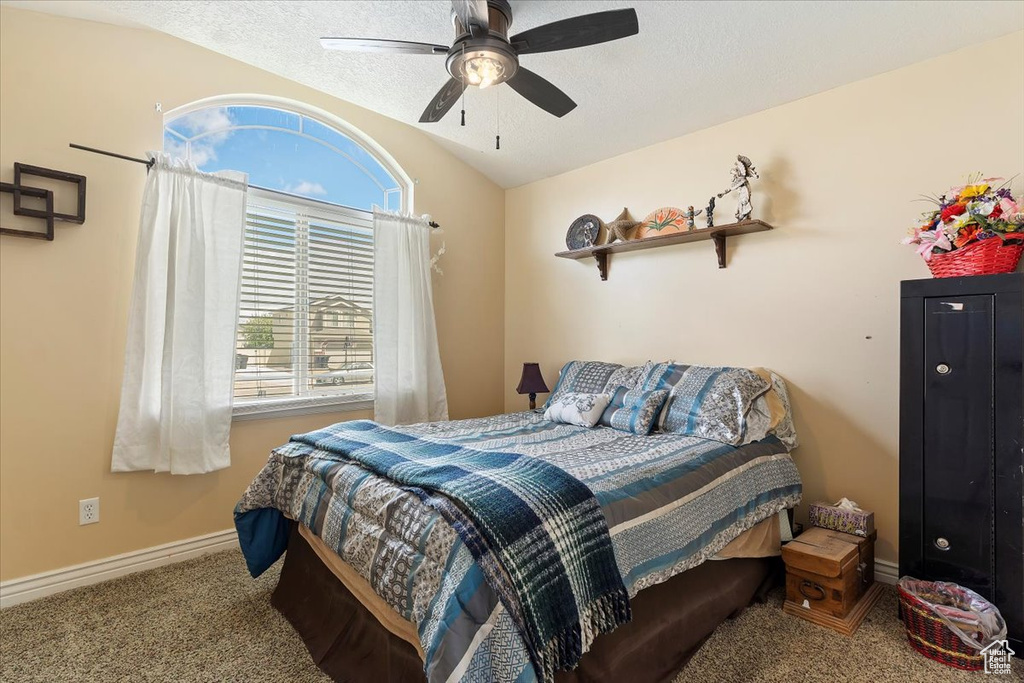 Bedroom featuring vaulted ceiling, carpet floors, and ceiling fan