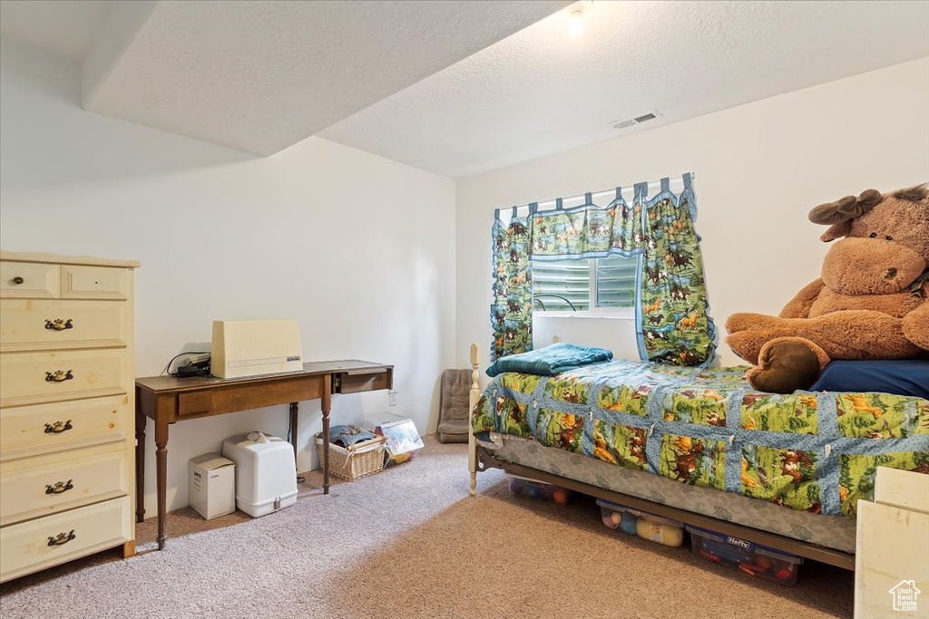 Bedroom featuring light colored carpet and a textured ceiling