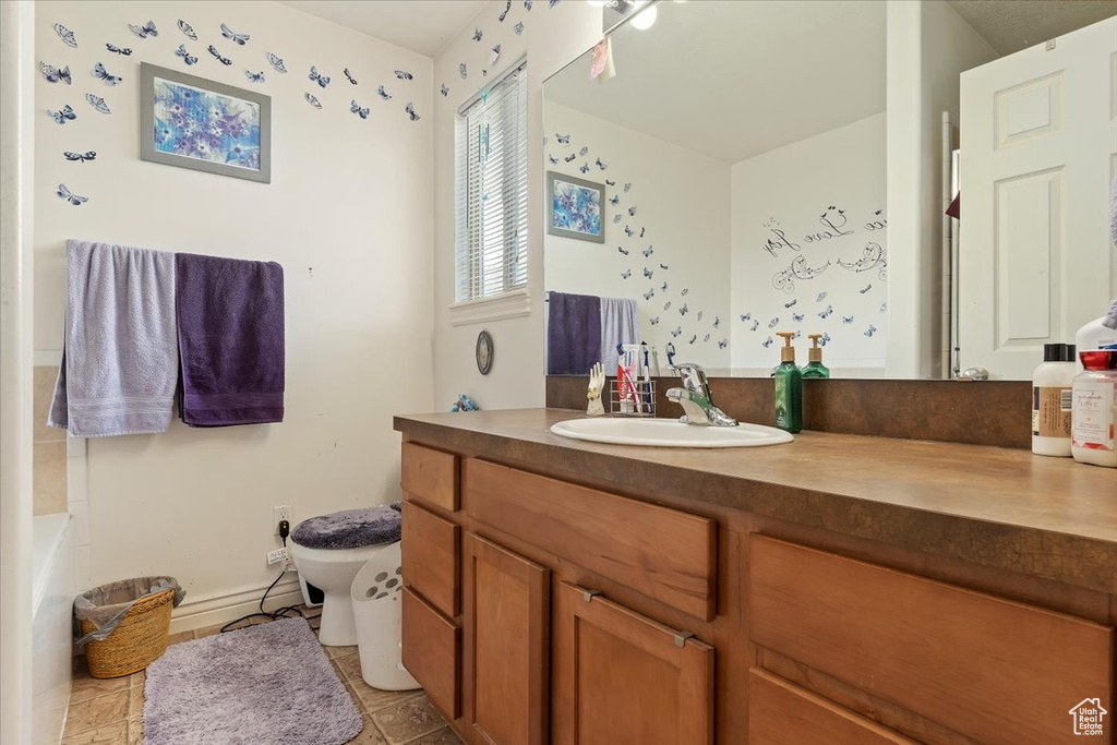 Bathroom featuring toilet, tile flooring, and vanity