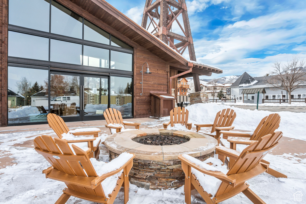 Snow covered patio featuring an outdoor fire pit