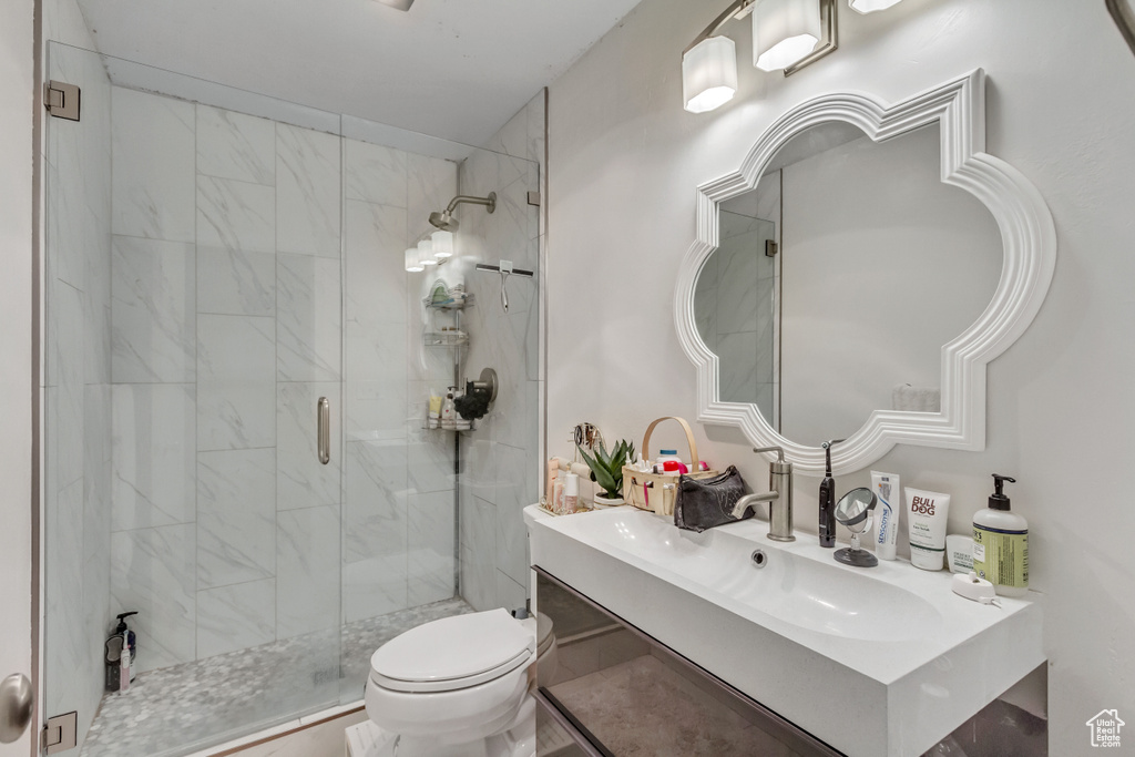 Bathroom featuring walk in shower, vanity, toilet, and tile floors