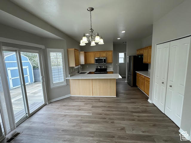 Kitchen with sink, black refrigerator, hardwood / wood-style floors, and range