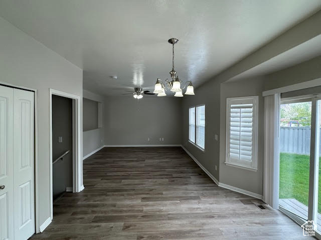 Empty room featuring hardwood / wood-style floors and an inviting chandelier