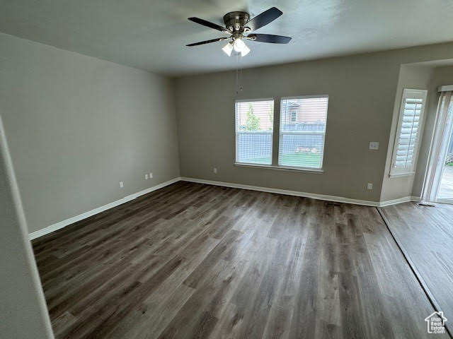 Empty room with dark hardwood / wood-style floors and ceiling fan
