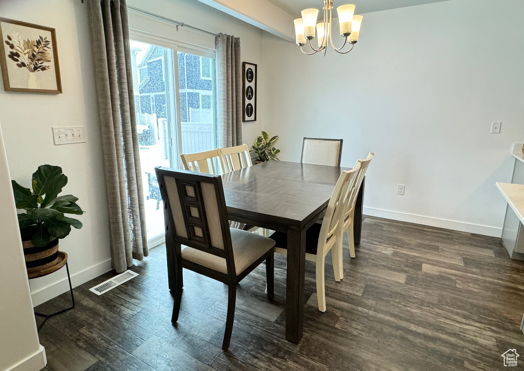 Dining area featuring dark hardwood / wood-style flooring and a chandelier