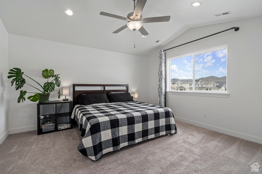 Bedroom with ceiling fan, carpet floors, and lofted ceiling