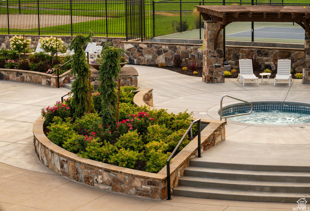 View of swimming pool featuring a hot tub, a pergola, and a patio