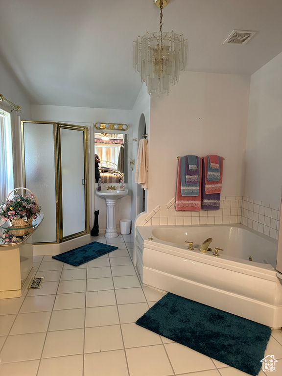 Bathroom with tile flooring, a notable chandelier, a wealth of natural light, and plus walk in shower