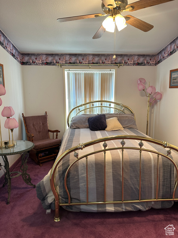 Bedroom with ceiling fan, carpet floors, and a textured ceiling