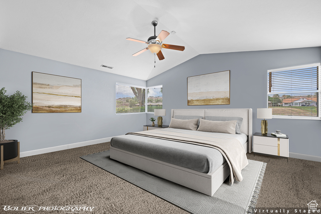 Bedroom with ceiling fan, dark carpet, and vaulted ceiling