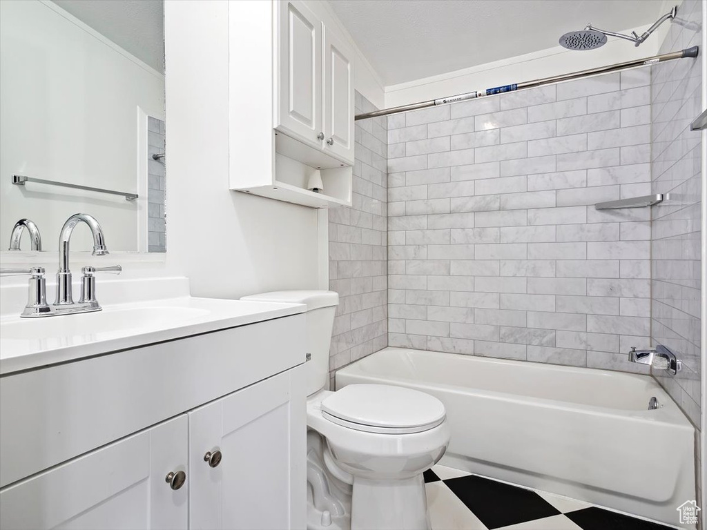 Full bathroom with tiled shower / bath, vanity, ornamental molding, tile flooring, and toilet