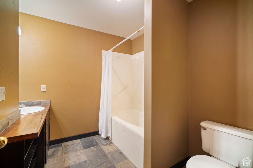 Full bathroom with shower / bath combo, toilet, tile floors, and vanity
