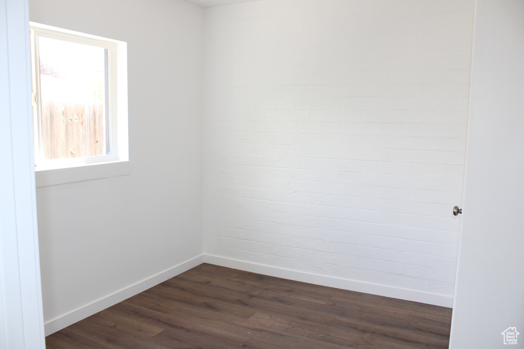 Empty room featuring dark hardwood / wood-style floors