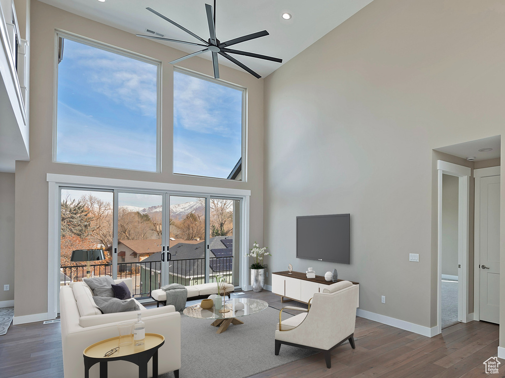 Living room featuring ceiling fan, high vaulted ceiling, and hardwood / wood-style floors