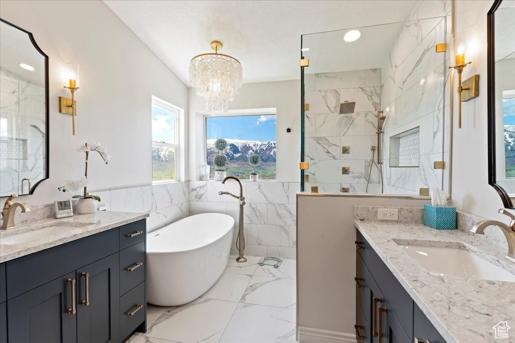 Bathroom featuring tile walls, vanity, tile floors, and a notable chandelier