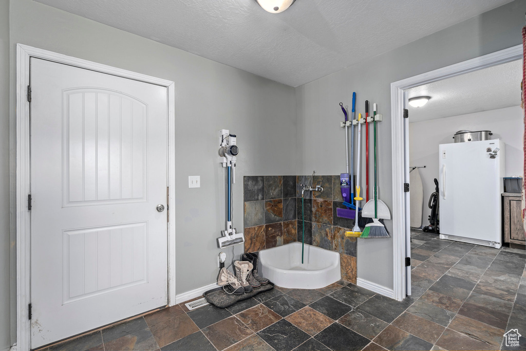Bathroom featuring tile flooring and a textured ceiling