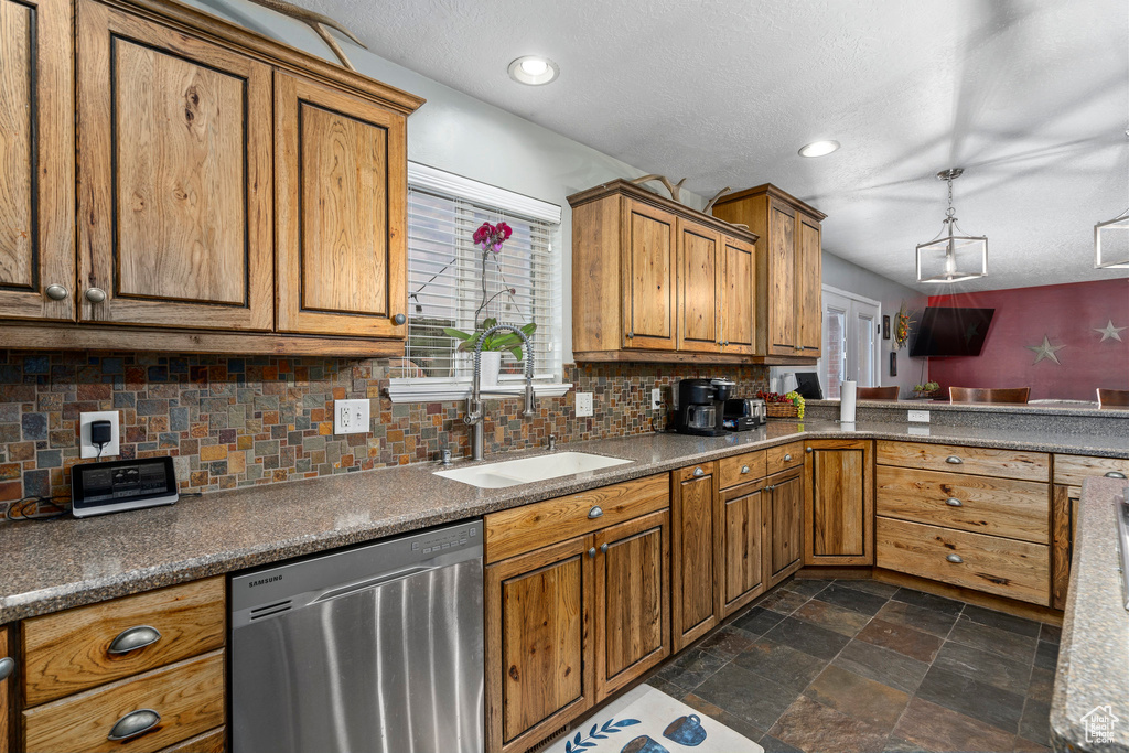 Kitchen with dark tile floors, sink, backsplash, stainless steel dishwasher, and decorative light fixtures