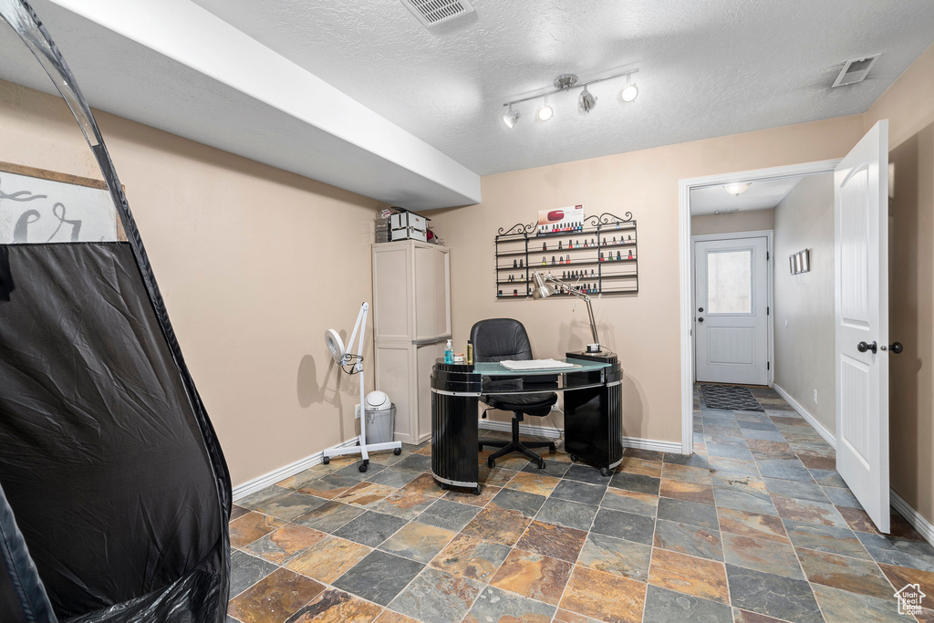 Tiled home office with track lighting and a textured ceiling