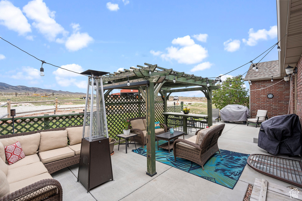 View of terrace featuring a mountain view, a pergola, an outdoor hangout area, and grilling area