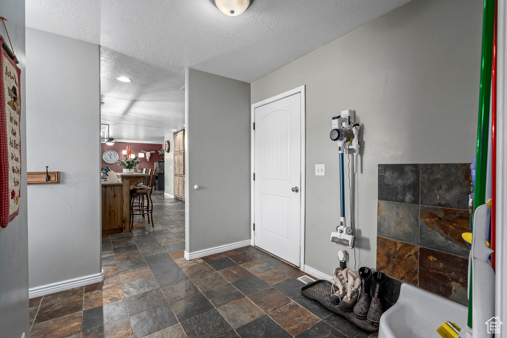 Interior space with a textured ceiling, vanity, and tile flooring