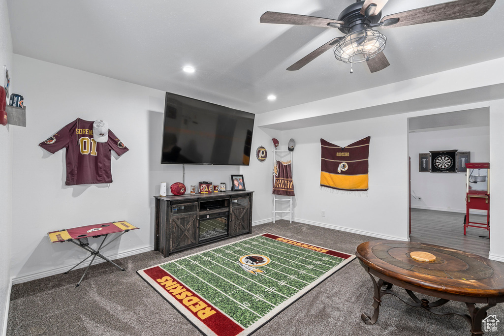 Living room with ceiling fan and dark carpet