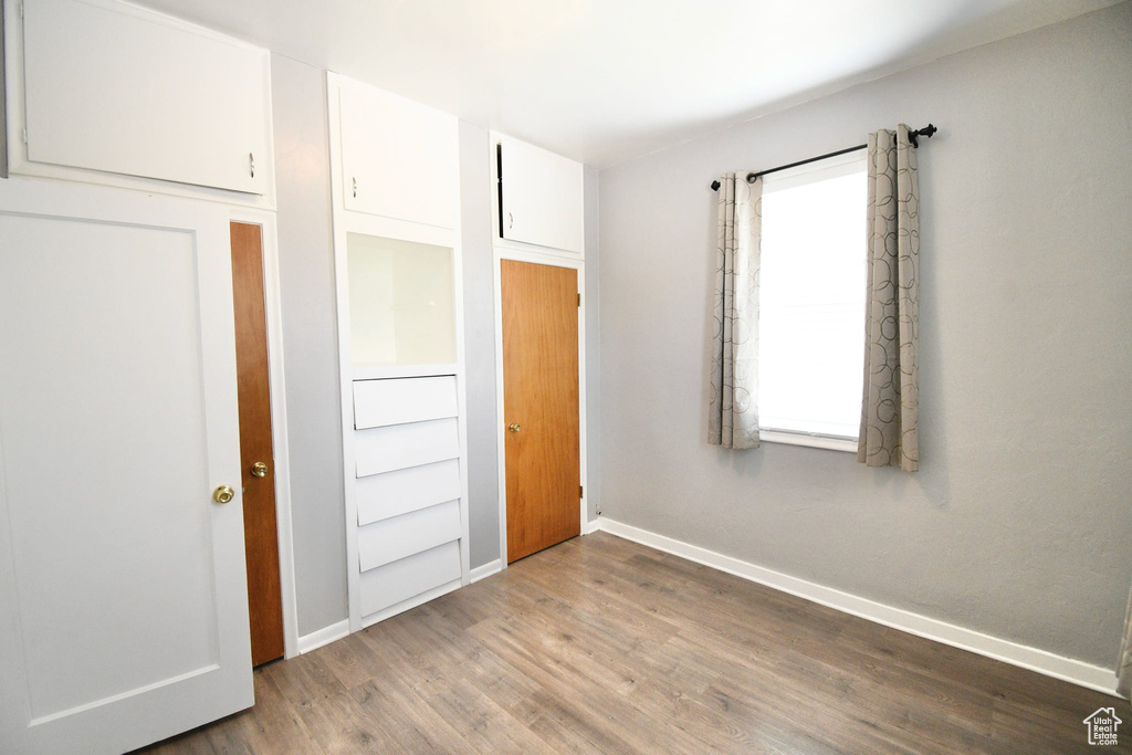 Unfurnished bedroom featuring hardwood / wood-style flooring and a closet