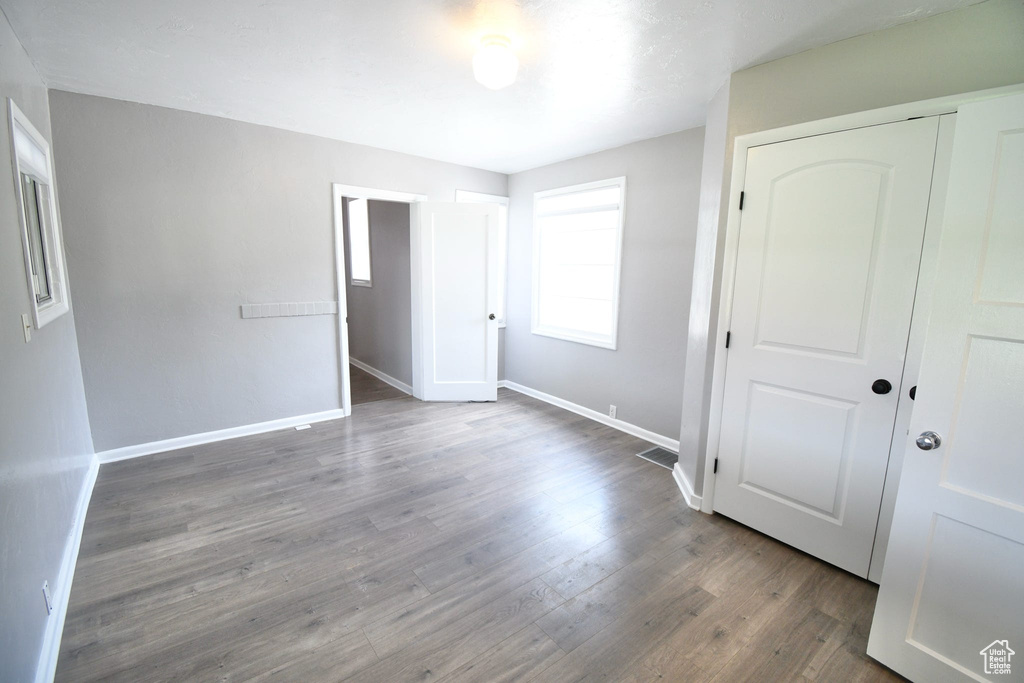Unfurnished bedroom with a closet and hardwood / wood-style floors