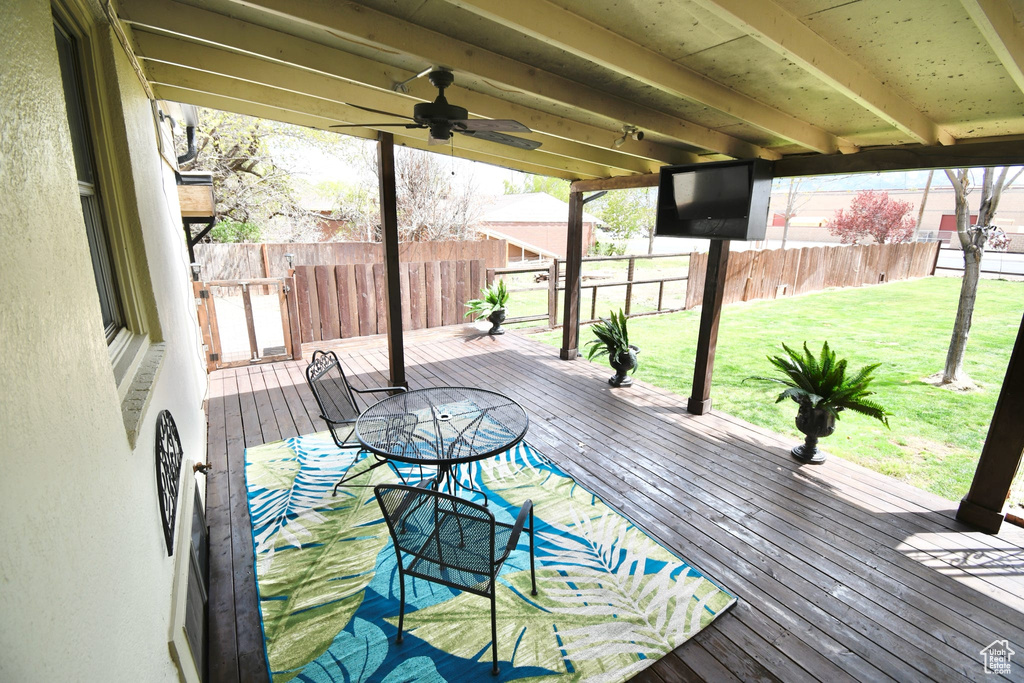 Wooden deck featuring ceiling fan and a lawn
