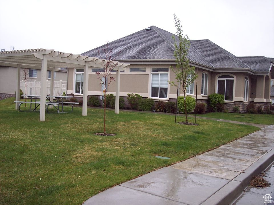 View of property exterior with a lawn and a pergola