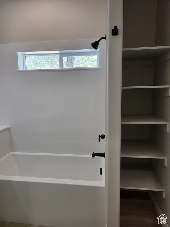 Bathroom featuring hardwood / wood-style flooring and plus walk in shower