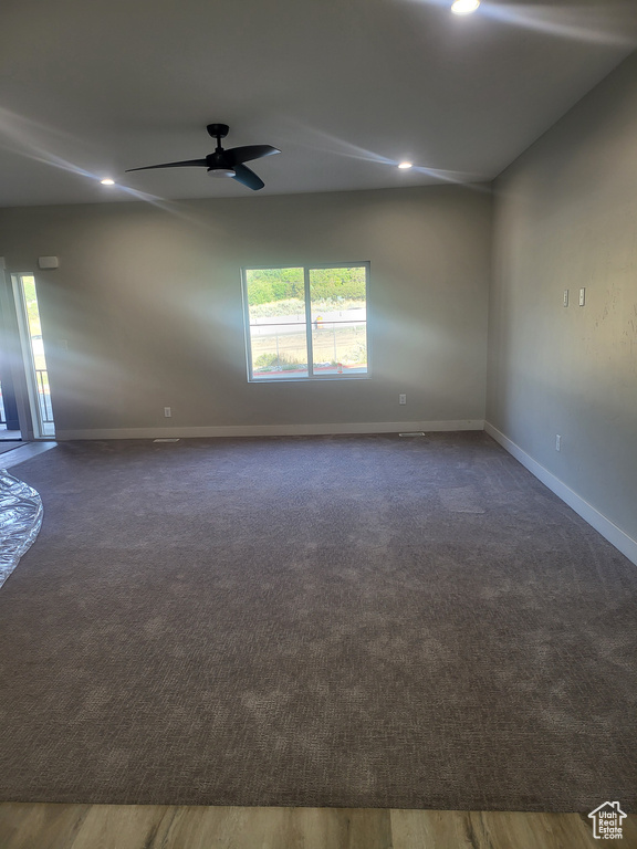 Unfurnished room featuring dark wood-type flooring and ceiling fan