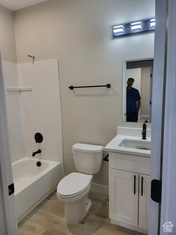 Full bathroom featuring hardwood / wood-style floors, toilet, bathing tub / shower combination, and vanity