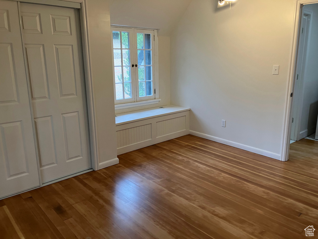 Unfurnished bedroom featuring hardwood / wood-style floors, a closet, and french doors