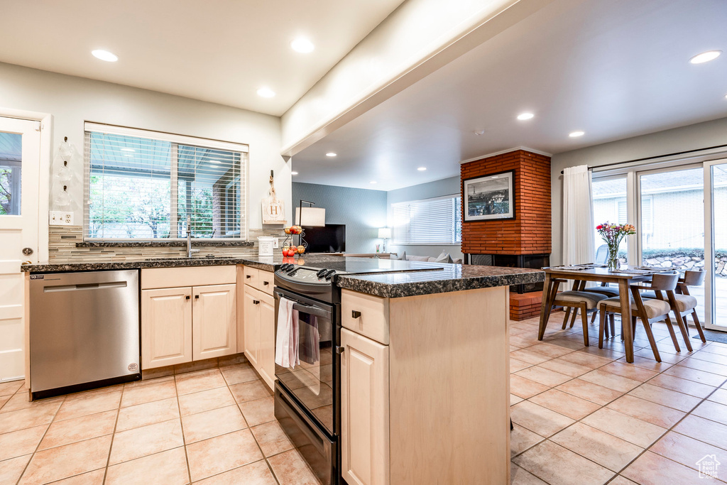 Kitchen featuring electric range oven, kitchen peninsula, a wealth of natural light, and stainless steel dishwasher