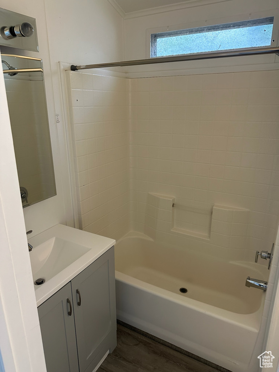 Bathroom featuring washtub / shower combination, vanity, hardwood / wood-style flooring, and crown molding