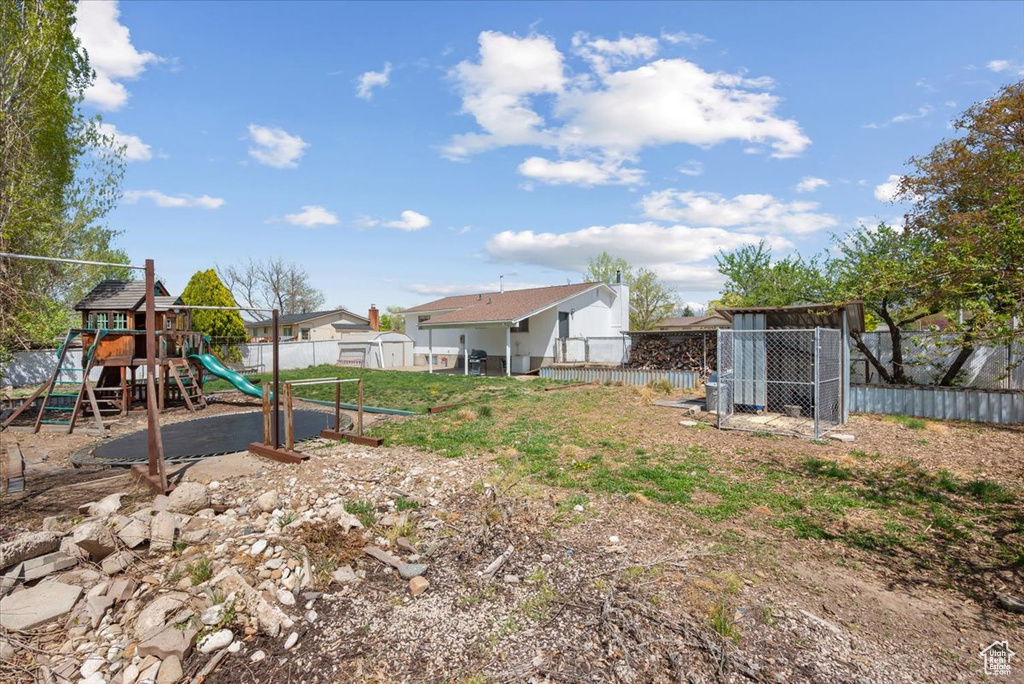 View of yard featuring a playground and a storage unit