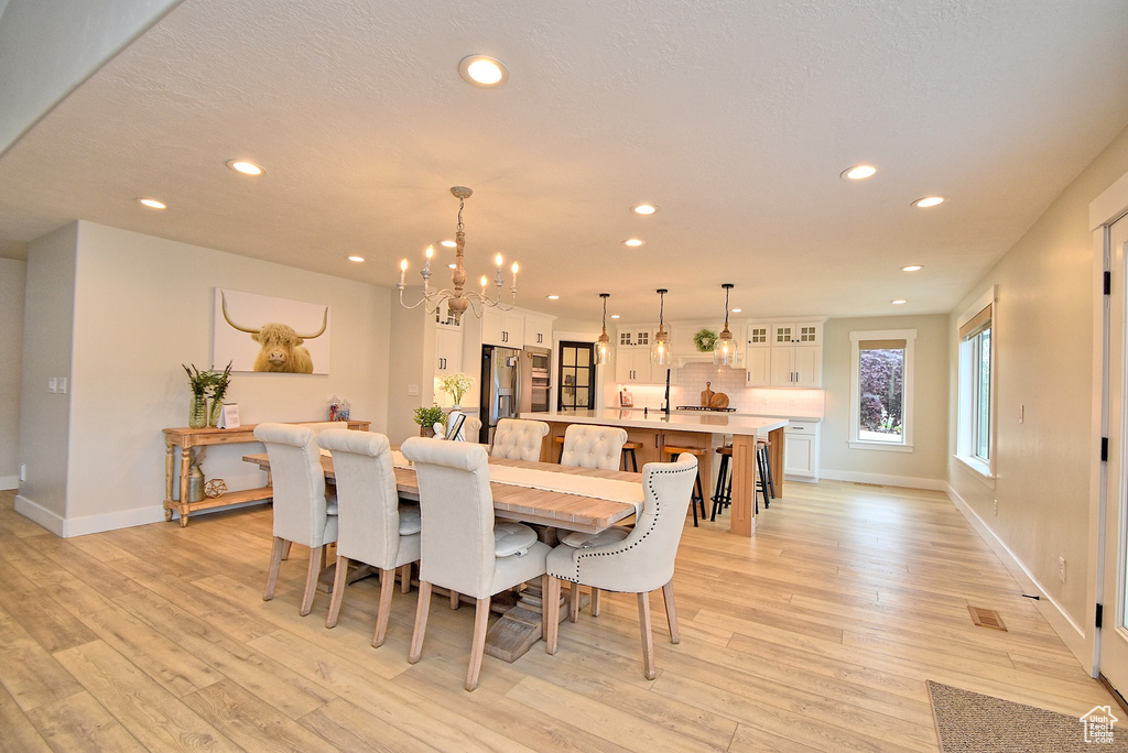 Dining area with light hardwood / wood-style floors and a chandelier