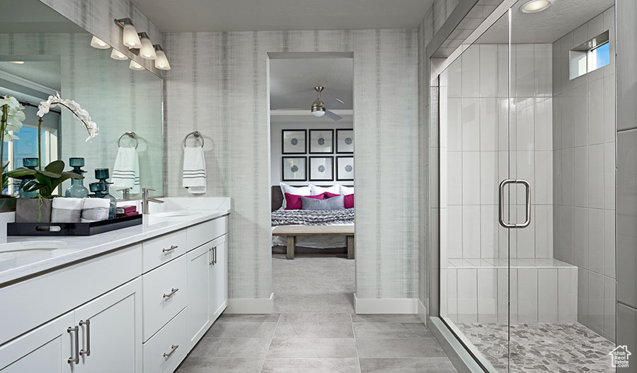 Bathroom with a shower with door, crown molding, tile floors, and double sink vanity