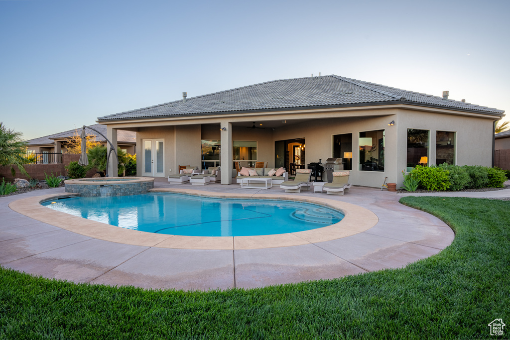 View of pool featuring a patio area, an outdoor hangout area, an in ground hot tub, and a yard